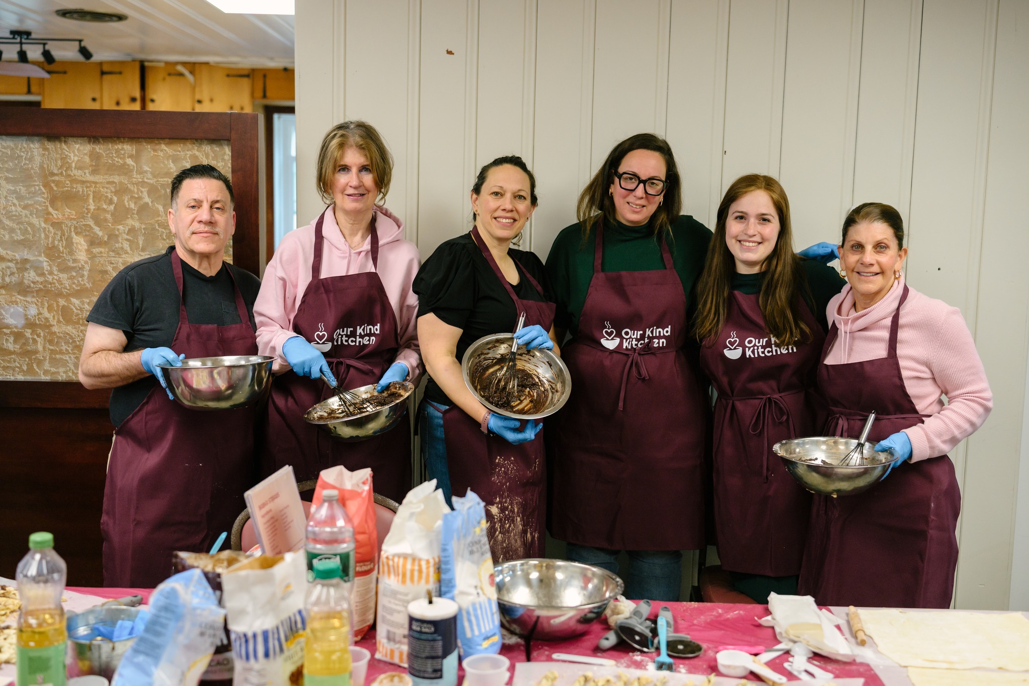 Volunteers preparing ingredients together around a long table