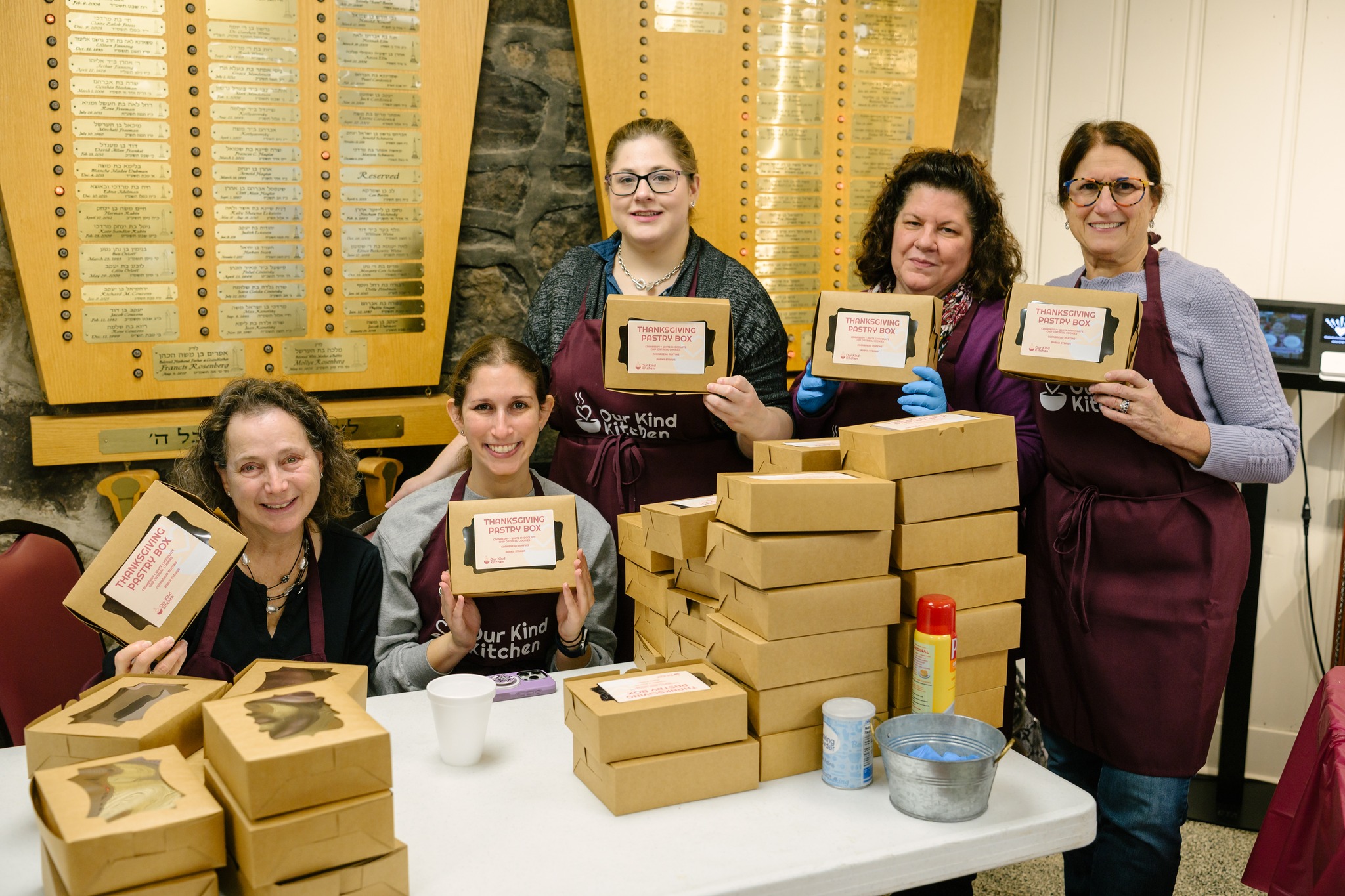 Volunteers with stacked boxes of packaged meals ready for delivery
